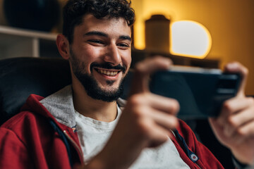 Close up view of a happy man winning the game on his phone