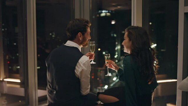 Attractive man flirting woman drinking champagne late evening. Couple relaxing.