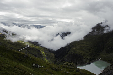A view of the Austrian Alps on the Grossglockner. A foggy day in the mountains. Landscape and blue lake.