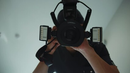 Blurred view of unrecognizable dentist holding black dental camera hi-res and taking photos of patient teeth at modern clinic. Indoors