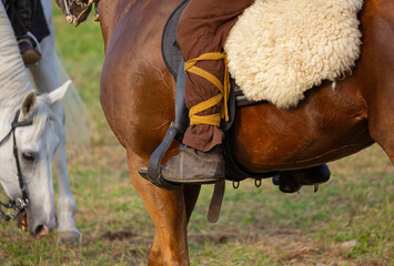 Closeup of a horse rider's leg in the stirrup at the annual ancient Roman historical reenactment in...