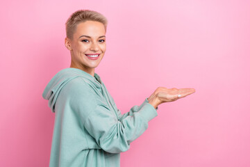 Profile photo portrait of attractive young woman toothy smile hold empty space dressed stylish khaki look isolated on pink color background