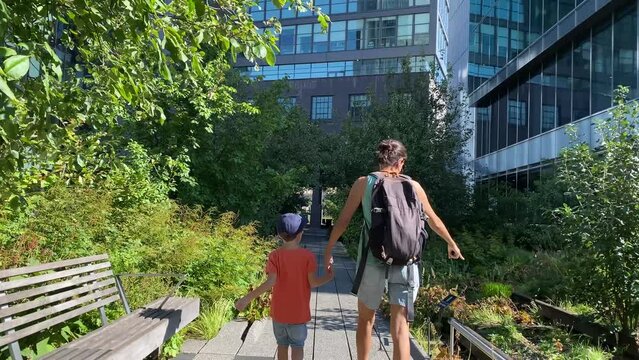 young woman with two children walk visit new york high line sunny day park garden tourist spot cosmopolitan city summer