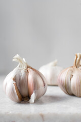 Garlic bulb on a marble tray, garlic with a clove taken out, raw garlic, Allium sativum