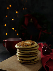Pancakes with festive accessories on dark background with bokeh