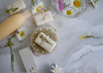 Fototapeta na wymiar Massage brush, soap, chamomile flower on a light background