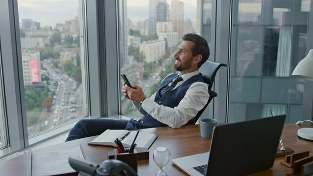 Happy worker reading smartphone message in cabinet. Businessman satisfied.