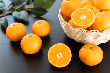 半分にカットしたみかんとたくさんのみかん