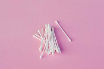 White cotton buds on pink background. Concept of hygiene, medicine, health care, beauty