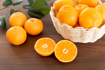 半分にカットしたみかんとたくさんのみかん