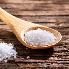 Fototapeta na wymiar White kitchen salt crystals in wooden spoon