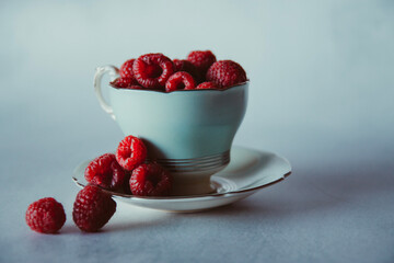 fresh raspberries in a vintage teacup