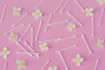 White buds near white jasmine flowers on light pink, close up. Skincare product for everyday beauty...