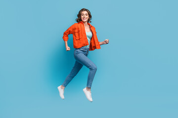 Fototapeta na wymiar Full body photo of young lovely lady flying running fast hurry sale shopping wear trendy orange outfit isolated on blue color background
