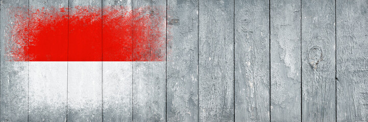 Flag of Monaco. Flag is painted on a gray wooden plank surface. Wooden background. Plywood surface. Copy space. Textured background