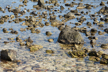 Rocks and waves on a sandy tropical beach.