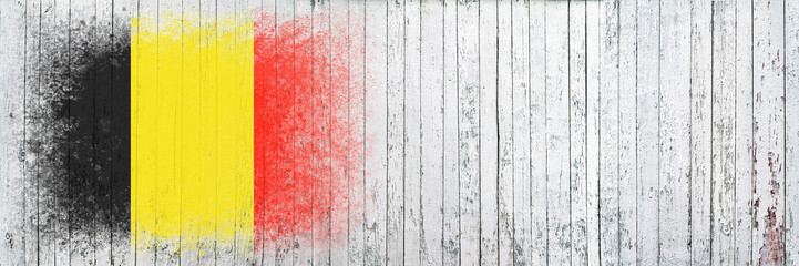 Flag of Belgium. Flag is painted on a white wooden surface. Wooden background. Plywood surface. Copy space. Textured background