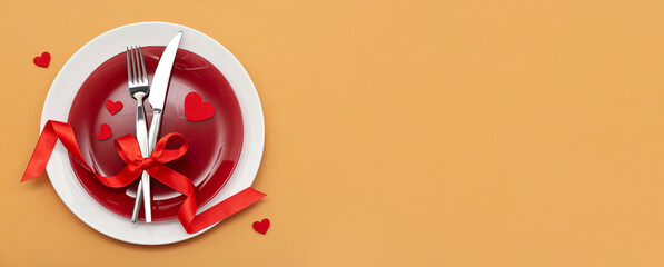Beautiful table setting for Valentine's Day on orange background with space for text