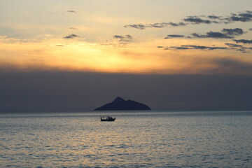 Naklejka na ściany i meble sunset with the vie of a small boat in the ocean near the island Paximadia in Greece 