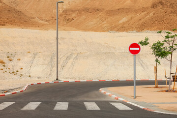 View of road with pedestrian crossing and No Entry sign in desert