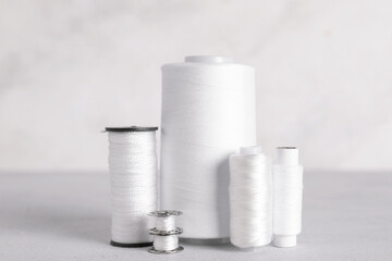 Different thread spools on light background
