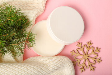 Obraz na płótnie Canvas Jar of cream, Christmas decor, sweater and coniferous branch on pink background, closeup