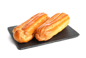 Slate board with tasty eclairs on white background
