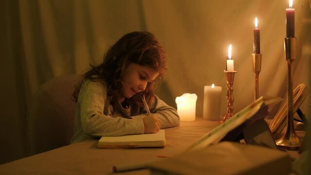 the girl writes in a notebook and then thoughtfully and dreamily stops looking up