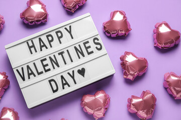 Board with text HAPPY VALENTINE'S DAY and balloons on violet background