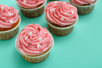 Tasty cupcakes for Valentine's Day on green background, closeup