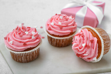 Board with tasty cupcakes for Valentine's Day on white background, closeup