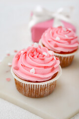 Board with tasty cupcakes for Valentine's Day on white background, closeup