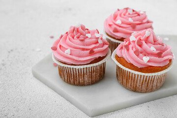 Board with tasty cupcakes for Valentine's Day on white background, closeup