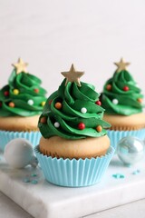 Christmas tree shaped cupcakes and decor on table