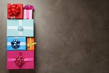 Many colorful gift boxes on grey table, flat lay. Space for text