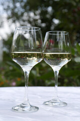 Glasses of white wine served on marble table outdoors