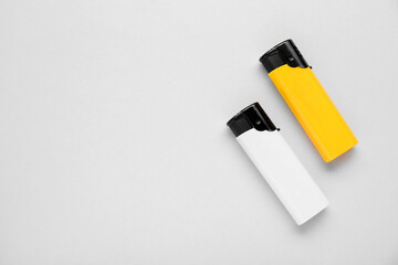 Stylish small pocket lighters on white background, flat lay. Space for text