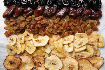 Different tasty dried fruits on paper, flat lay