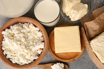 Tasty homemade butter and dairy products on grey table, flat lay