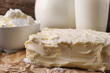 Tasty homemade butter and dairy products on parchment, closeup