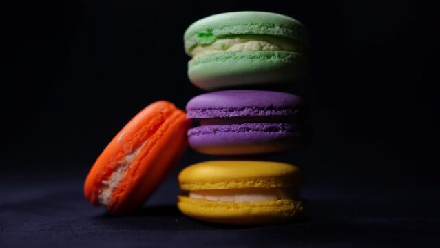 Sweet delicate macarons black background. Colorful macarons cakes. Small French cakes. Sweet and colorful french macaroons.