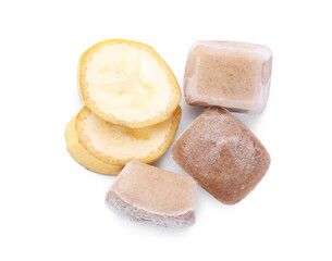 Frozen banana puree cubes and fruits on white background, top view