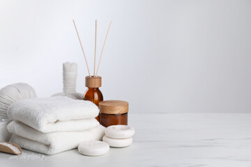 Fototapeta na wymiar Spa composition with care products on white marble table. Space for text