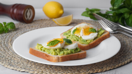 Tasty sandwiches with boiled egg, avocado and spinach on table, closeup