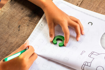 English alphabet made of square wooden tiles with the English alphabet scattered on hand. The...