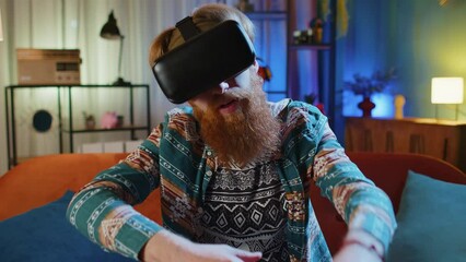 Man using virtual reality futuristic technology VR app headset helmet to play simulation 3D 360 video game watching film movie at home apartment. Guy in goggles sitting on sofa. Transition zoom effect