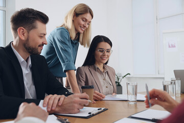 Businesswoman having meeting with her employees in office