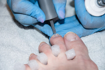 pedicure master applies gel polish on client's toe nails, Client's foot 