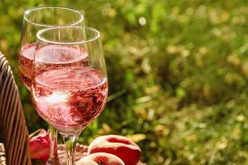 Glasses of delicious rose wine outside, closeup. Space for text