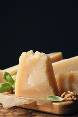 Delicious parmesan cheese with walnuts and basil on wooden table, closeup